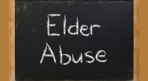 A chalk board that has "elder abuse" written on it.