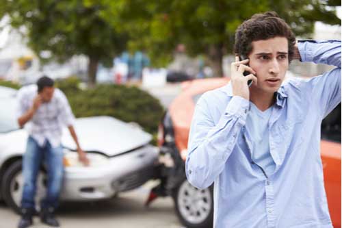 Driver calling Greenville car accident lawyer at crash scene
